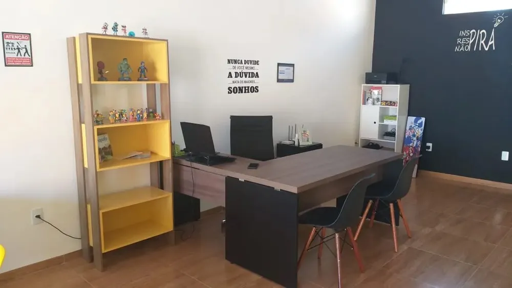 Mesa de trabalho e estante com coleção de bonecos